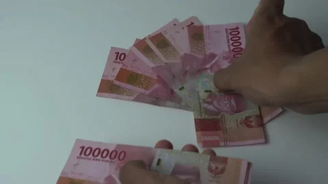Man's hand counting one hundred thousand rupiah bills, indonesian money on a  Stock Footage 222278073