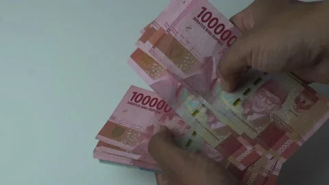 Man's hand counting one hundred thousand rupiah bills, indonesian money on a  Stock Footage 222278539
