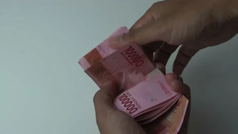 Man's hand counting one hundred thousand rupiah bills, indonesian money on a  Stock Footage 222279798