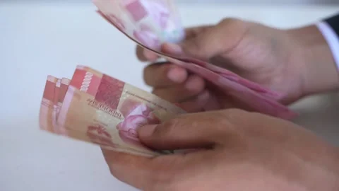 Man's hand counting one hundred thousand rupiah bills Stock Footage 322159554