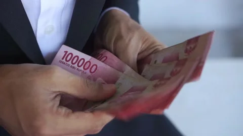 Man's hand counting one hundred thousand rupiah bills Video stock 322159582