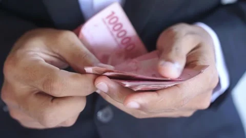 Man's hand counting one hundred thousand rupiah bills, Stock Footage 322159583