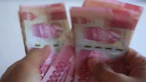 Man's hand counting one hundred thousand rupiah bills Stock Footage 322159601