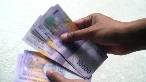 Man's hand is counting ten thousand rupiah banknotes Stock Footage 304402319