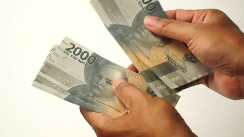 Man's hand counting two thousand rupiah banknotes Stock Footage 294453345