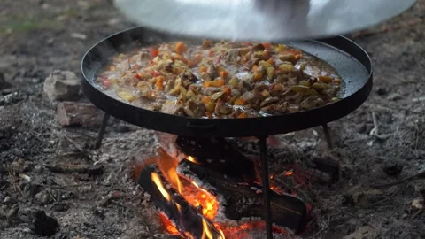 A man's hand covers potatoes with vegetables with a lid Video stock 278730872