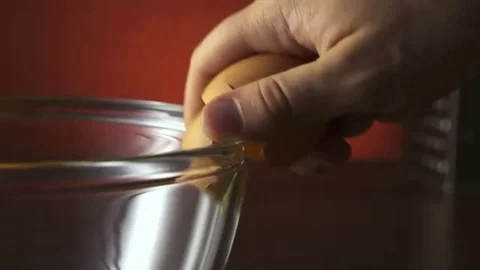 Man's Hand Cracking and pouring an Egg into a Bowl. Stock Footage 98557457