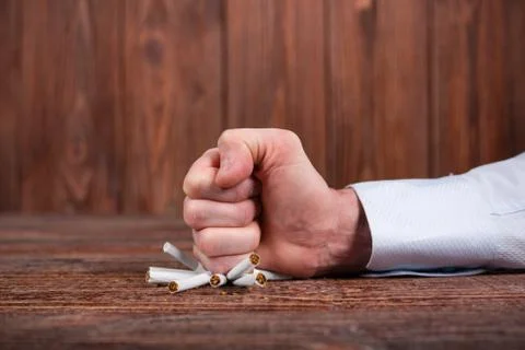 Man's hand crushing cigarettes. Quit smoking. Concept. Stock Photos