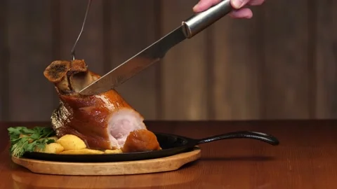A man's hand cuts an appetizing meat dish into the bone with a knife. Ready meat Vidéo 143228783