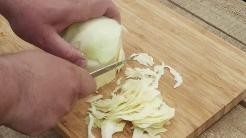 Man's hand cuts cabbage with a knife on a wooden board Vídeos de archivo 195397894