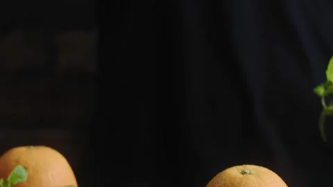 Man's hand cuts fresh orange in half with sharp knife on cutting board Stock Footage 149093494