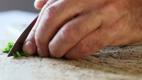 Man's hand cutting basil leaves on a wooden board. Stock Footage 195947982