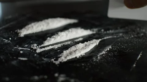 Man's hand cutting illegal white cocaine drug on a black background. Vídeo Stock 219324914
