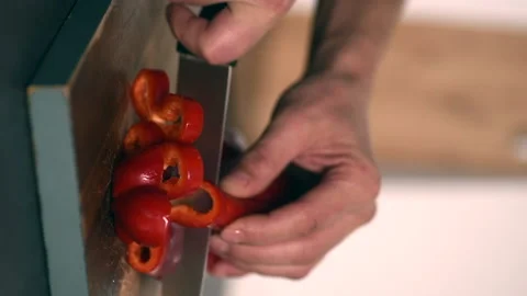 Man's Hand Cutting a Red Sweet Pepper on a Wood Cutting Board Stock Footage