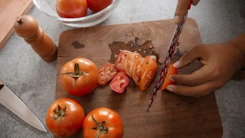 Man's hand cutting tomatoes on a cutting board Stock Footage 272181616