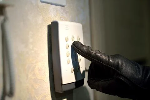 Man's hand dials the code from the security system at home on a keypad with Stock Photos