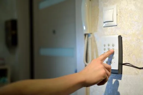 Man's hand dials the code from the security system at home on a keypad with n Foto stock