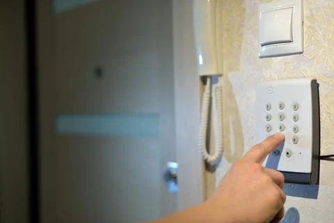 Man's hand dials the code from the security system at home on a keypad with n Stock Photos