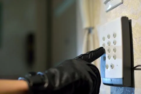 Man's hand dials the code from the security system at home on a keypad with n Stock Photos