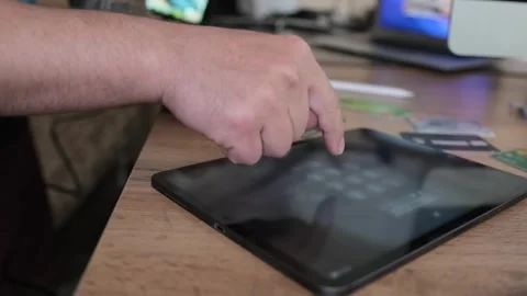 Man's hand dials code on tablet with his index finger to unlock it. 스톡 동영상 242968848