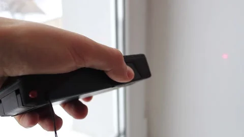 Man's hand with a digital rangefinder measures the distance Stock Footage 224550698
