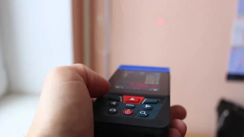 Man's hand with a digital rangefinder measures the distance Stock Footage 224550823