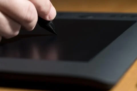 Mans hand drawing on a computer graphics tablet Stock Photos