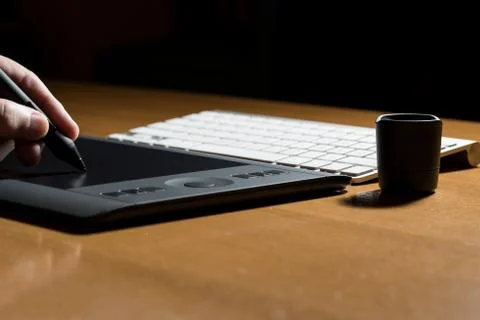 Mans hand drawing on a computer graphics tablet Stock Photos