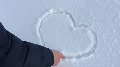 Man's hand draws a heart in the snow. Stock Footage 101229649