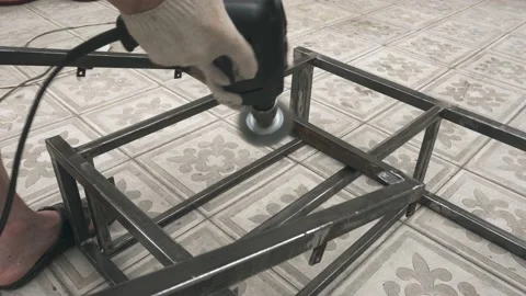 A man's hand with a drill in his hands thoroughly cleans the metal frame 库存影片 145395282
