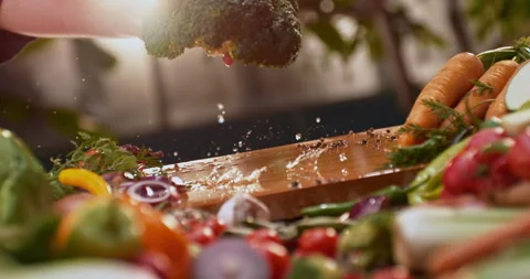 Man's hand dropping a broccoli on board Stock-Footage 311833574