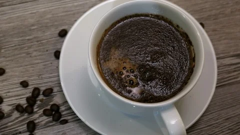 Man's Hand Dropping Sugar Into Coffee Cup On Table Slider Shot. Stock Footage 116562050