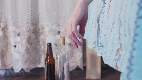 Man's hand drops an empty bottle Stock Footage 155493889