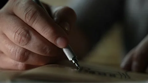 Man's hand is drowing on the old paper. Pen Writes On Paper In Blue Ink. Close Stock Footage 201067783