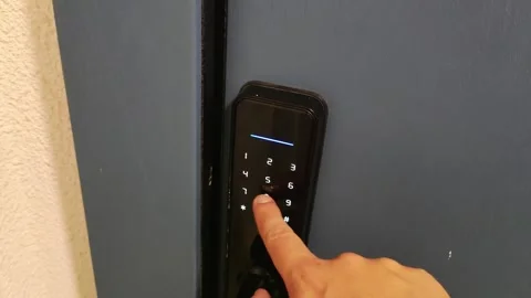A man's hand enters an electronic code for a door lock. A modern way to protect Stock-Footage 254064134