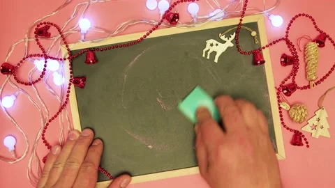A man's hand erases let it show on the black board and write the end. Stock Footage 145001565