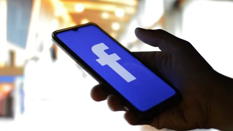 Man's hand with facebook social network app logo on the phone. FB by meta Stock Footage 200864236