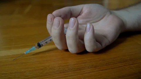 Man's hand Falls to floor just pricked drugs Stock-Footage 121619630