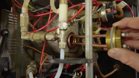 A man’s hand fitting a water heater element to an espresso machine boiler. Vídeos de archivo 294824890