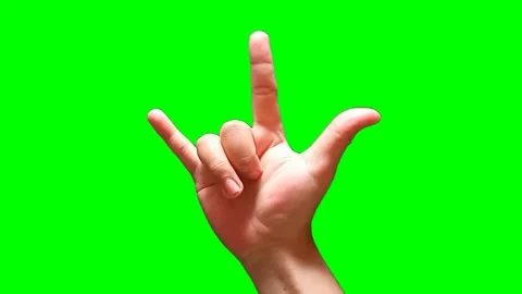 A man's hand forming a devil horn on a green screen background Stock Footage 340357386