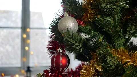 A man's hand hangs silver ball on spruce branch of christmas tree for Stock Footage 143795021