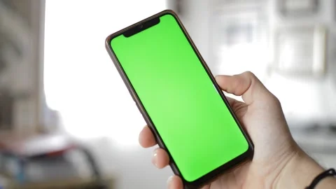 Man's hand hold iphone device by apple with green screen display. Stock Footage 237431258