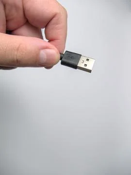 A man's hand holding and preparing to plug in USB cable Stock Photos