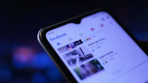 Man's hand holding and scrolling facebook social network app Vidéo 201921248