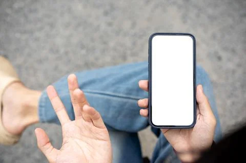 A man's hand holding a blank screen smartphone making confused gesture whil.. 写真素材