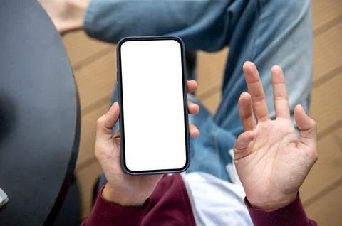 A man's hand holding blank screen smartphone making confused gesture while .. 写真素材