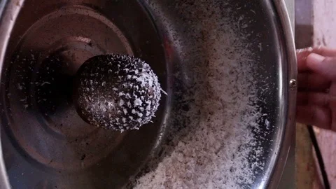 The man's hand is holding coconuts to grate on coconut grate. Stock Footage 104991881