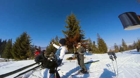 Man's hand holding a cup in the background of people skiers in the mountains Video stock 105269668
