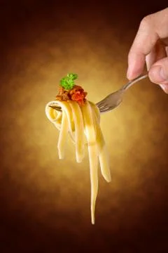 Mans hand holding a fork with pasta Stock Photos