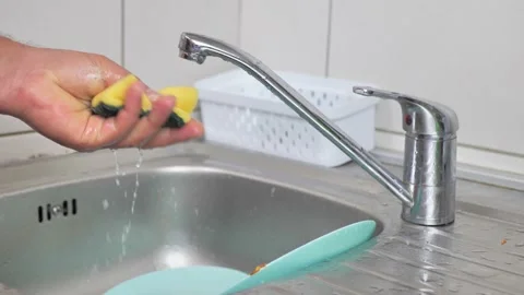 A Man's Hand Holding a Kitchen Sponge With a Few Drops of Dishwashing Gel Video stock 220265901